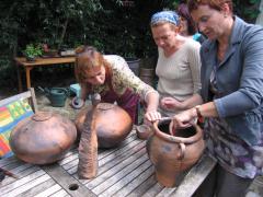 Raku is een traditionele Japanse stooktechniek. Gloeiend heet uit de oven wordt het geglazuurde werkstuk in een ton met zaagsel gelegd.